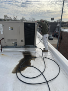 An HVAC technician servicing a commercial rooftop unit for Dent Turner Air Conditioning Sales in Vaiden, MS.