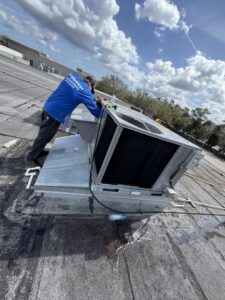 An HVAC technician servicing a commercial rooftop air conditioning unit for Whitleys Heating and Air in Jacksonville, FL.