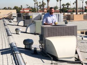 An HVAC technician servicing commercial rooftop units for Diamond AC and Heating in Phoenix, AZ.