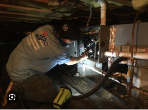 An HVAC technician from Subzero Mechanical LLC Heating & Air servicing an indoor unit in Concord, NC.