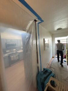 An HVAC technician from Fuse HVAC & Appliance Repair Boston setting up an air scrubber for air quality in West Roxbury, MA.