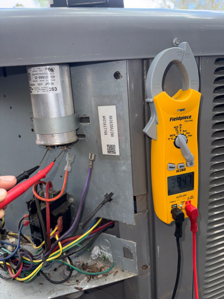 An HVAC technician testing an outdoor AC unit with a multimeter for AC All Stars AC contractor in Fort Lauderdale, FL.