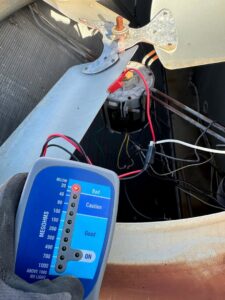 An HVAC technician using a megohmmeter to test a motor, demonstrating diagnostic services from Air Casablanca Heating & Cooling in Myrtle Beach, SC.