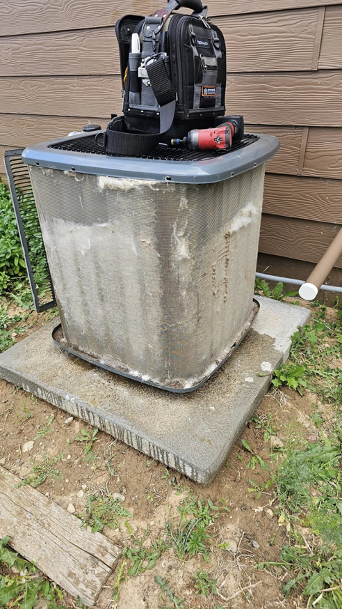 HVAC tools on top of an outdoor AC unit with dirty coils, ready for service by Erik's Quality HVAC LLC in Greeley, CO.