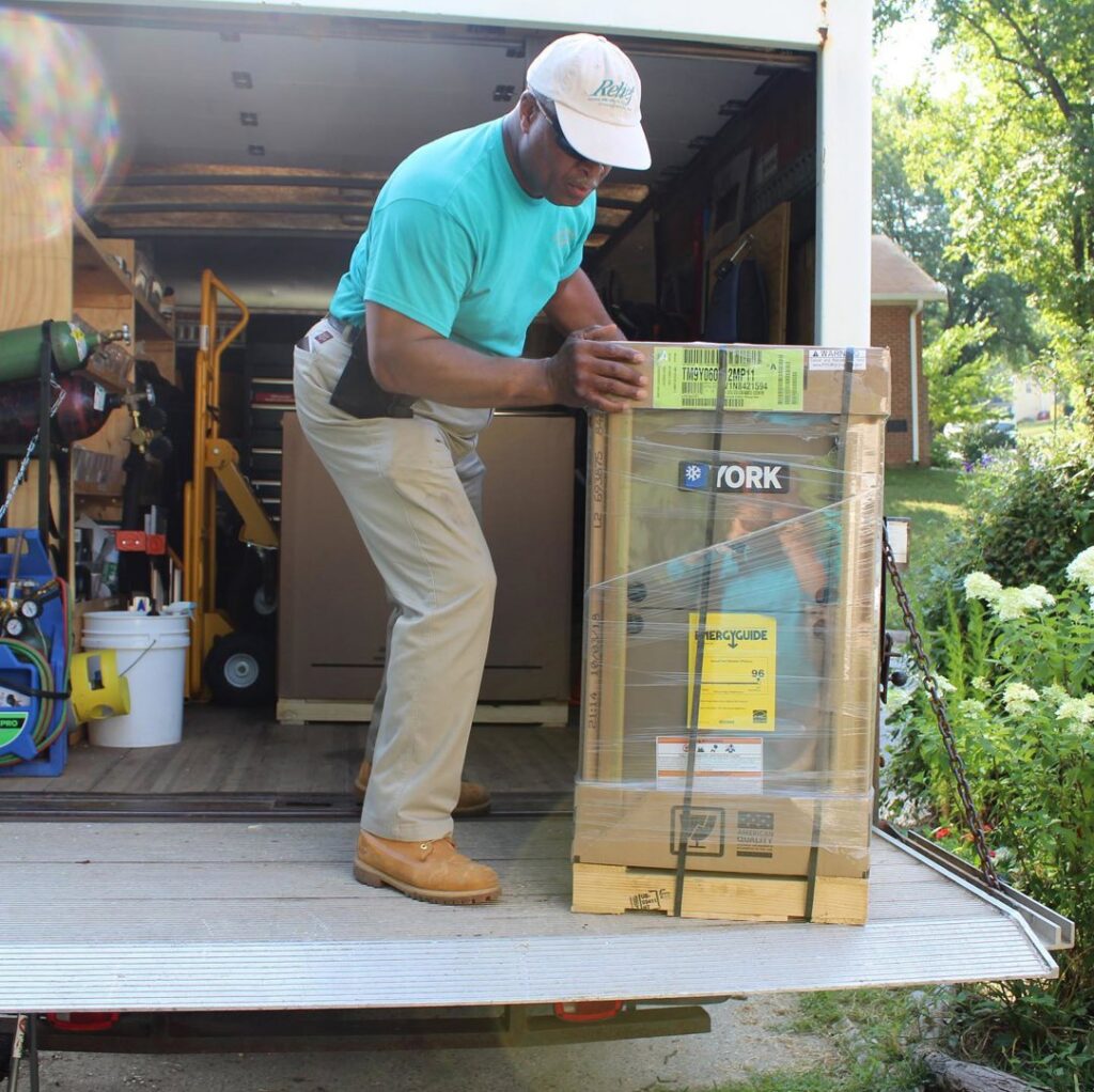 An HVAC technician unloading a new York HVAC unit from a service truck for installation by Relief Heating and Cooling, LLC in Greensboro, NC.