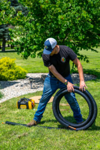 An HVAC technician from Comfort Craftsman Heating & Cooling unrolling insulated refrigerant lines for an installation in Westland, MI.