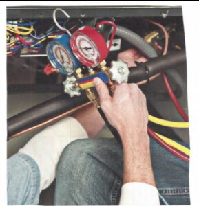 An HVAC technician using manifold gauges to check a system for Carolina Heating & Air Conditioning in Fayetteville, NC.