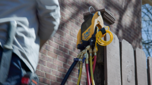 An HVAC technician using manifold gauges for a system check at Integrity Airworks in Hoover, AL.