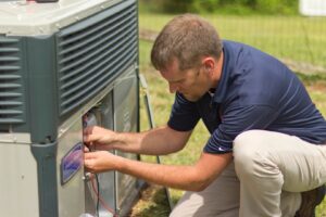 An HVAC technician carefully wiring an outdoor air conditioning unit for Comfort Zone of the Carolinas in Rock Hill, SC.