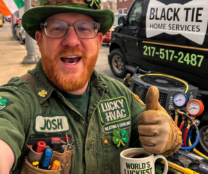 An HVAC technician with an outdoor air conditioning unit and tools from Black Tie Home Services in Springfield, IL