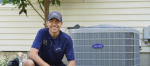 A Five Star Heating & Cooling Group technician smiling next to an outdoor AC unit in Dayton, OH.