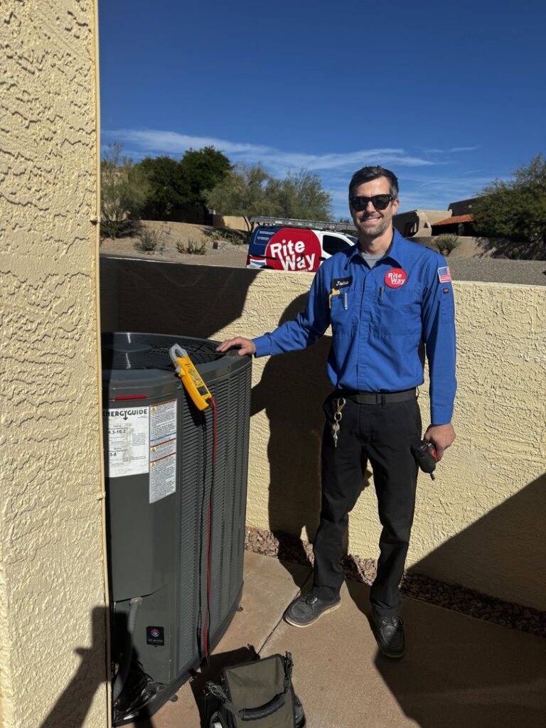 An HVAC technician from Rite Way Heating, Cooling & Plumbing of Phoenix, AZ, standing next to an outdoor AC unit.