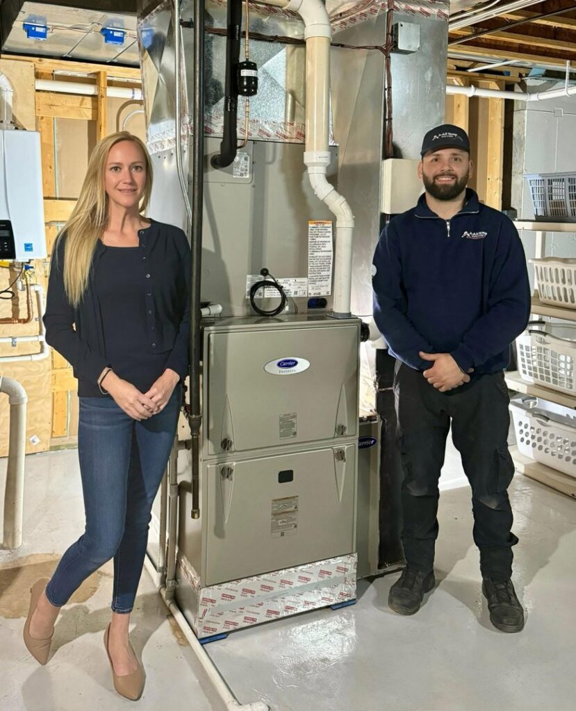 An HVAC technician and customer with an indoor furnace installed by A All Temp Inc. Heating & Cooling in Naperville, IL.