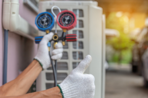 An HVAC technician holding manifold gauges for refrigerant check, giving a thumbs-up for Southside Energy in Chesapeake, VA.