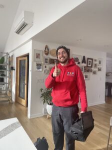 An HVAC technician from Bloomington Heating & Air giving a thumbs up after installing a mini-split unit in a home in Bloomington, MN.