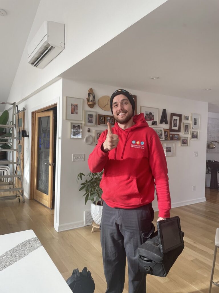 An HVAC technician from Bloomington Heating & Air giving a thumbs up after installing a mini-split unit in a home in Bloomington, MN.