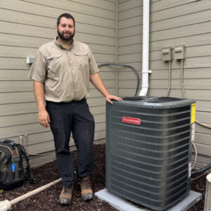 An HVAC technician standing next to an outdoor air conditioning unit after service by Polar Air Heating and Cooling in Omaha, NE