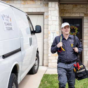 An HVAC technician from Mr. Cool HVAC walking with tools and gauges near a branded service van in Cypress, TX.