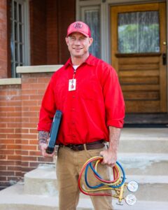 A Jump HVAC technician holding a tool case and refrigerant gauges, ready for service in Lakewood, CO.