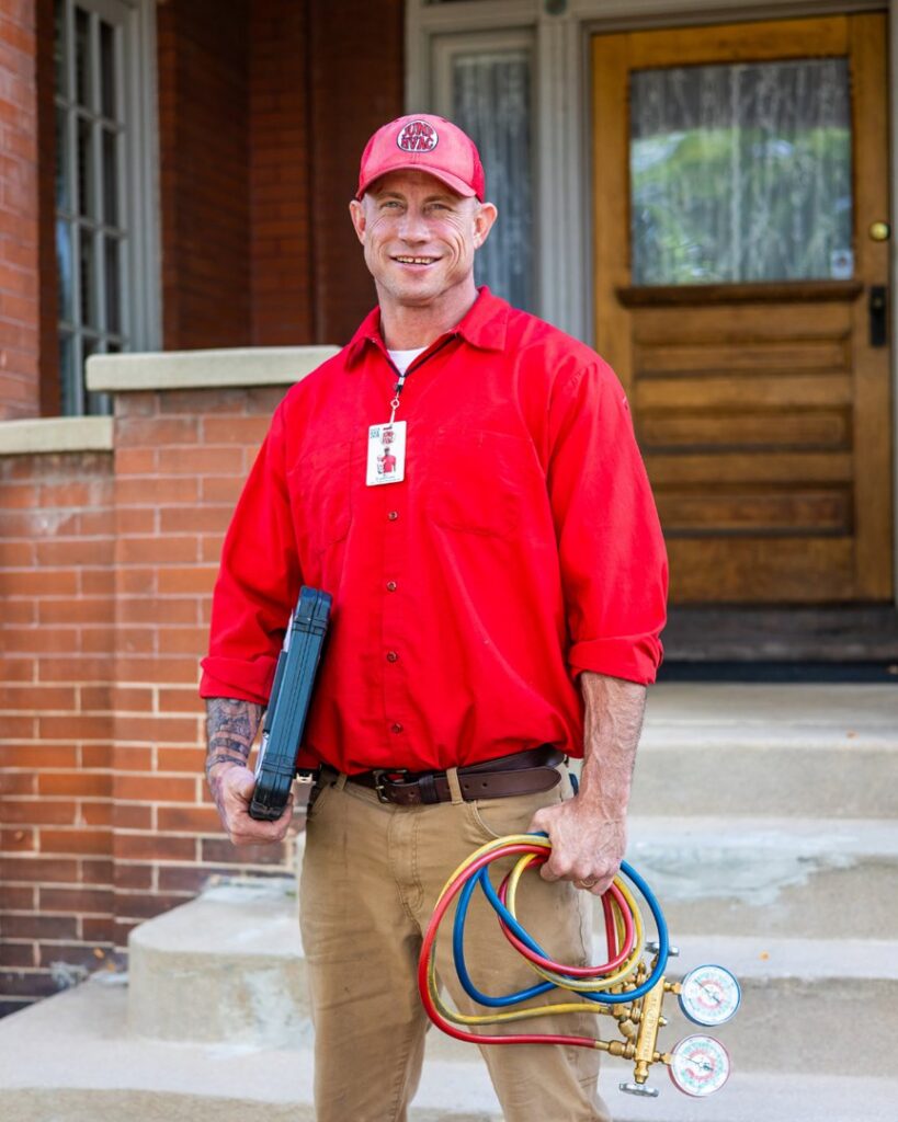 A Jump HVAC technician holding a tool case and refrigerant gauges, ready for service in Lakewood, CO.