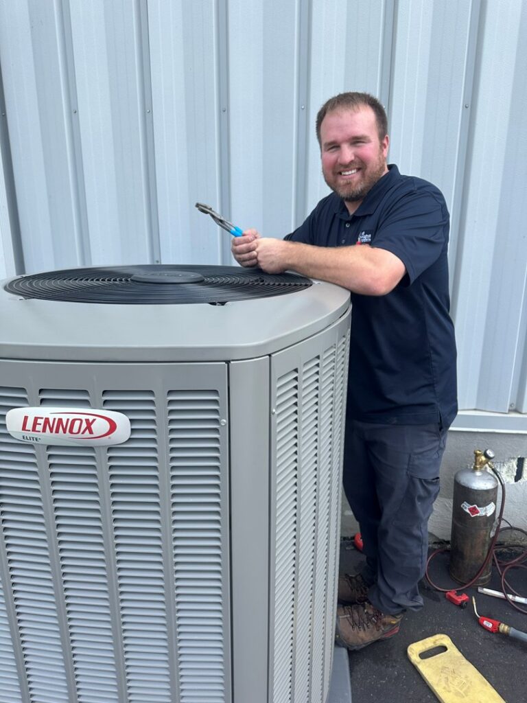 An HVAC technician with a wrench next to a Lennox air conditioning unit, performing service for All Comfort Services in Madison, WI