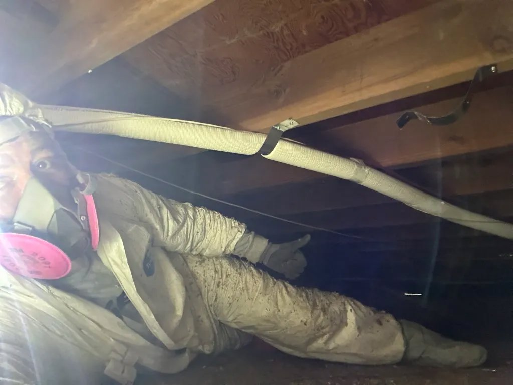 An HVAC technician from Fuse HVAC & Appliance Repair Boston working in a crawl space in West Roxbury, MA.
