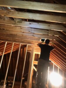 An HVAC technician from B&B Hvac Llc in Memphis, TN, installing ductwork in an attic.