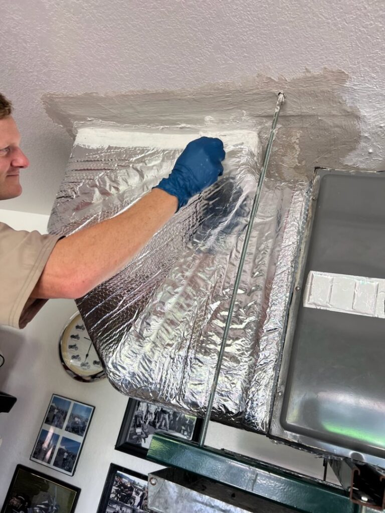 An HVAC technician from Seven Level Services Inc in Cape Coral, FL, working on an indoor air handler unit.