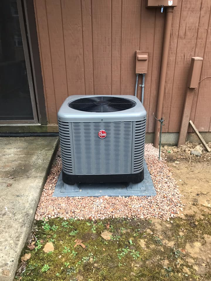 An HVAC technician working on an outdoor AC unit installation for George Mechanical in Charleston, WV.