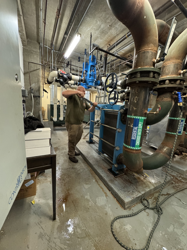 An HVAC technician working on a condensed water supply system for a commercial unit by APEX HVAC Solutions LLC in Frederick, MD.