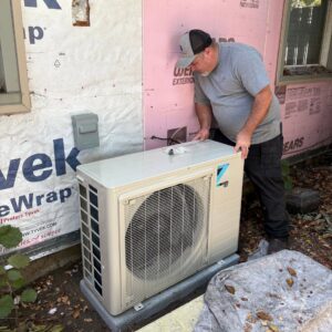An HVAC technician from DiMartino's 5 Star Heating & Air Conditioning LLC working on a Daikin outdoor unit in Salem, OR.