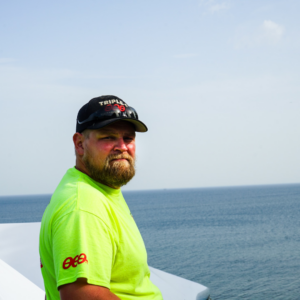 An HVAC technician from Triple-O working on the internal wiring of a furnace or air handler in Bergen, NY.