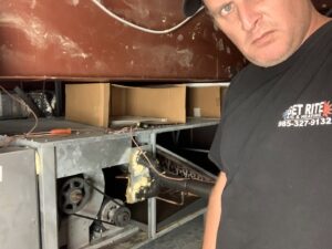 An HVAC technician working on the internal components of an indoor air conditioning or heating unit for Get RiTe A/C & Heating in Madisonville, LA.