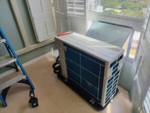 An HVAC technician performing service on an indoor mini-split unit, demonstrating work by Air Masters, Inc. in Port Orchard, WA.