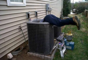 An HVAC technician working on an outdoor air conditioning unit for General Air Conditioning Service Corp in Greenville, SC.