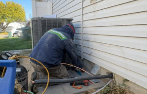 An HVAC technician from Greens Heating & Air Conditioning working on an outdoor air conditioning unit in Douglasville, GA.