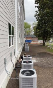 An HVAC technician from Comfort Shield HVAC Services of NC performing maintenance on an outdoor unit in Smithfield, NC.