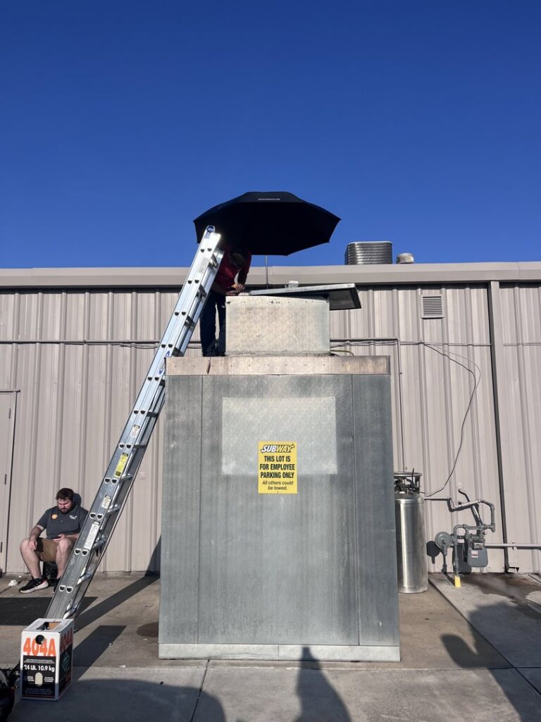 An HVAC technician from Springfield HVAC Company working on a commercial rooftop unit in Springfield, MO.