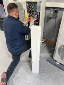 An HVAC technician working on the internal components of an HVAC unit for Jaguar Heating & Air in Sacramento, CA