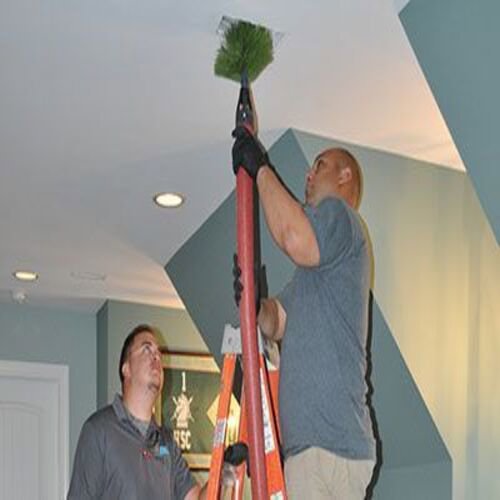HVAC technicians cleaning an air duct vent as part of service from Foust Heating & Air Conditioning in Fayetteville, NC.
