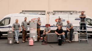 The Heating Specialist HVAC technicians posing with various equipment and service vans in Portland, OR