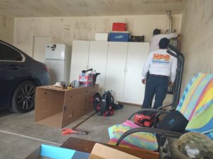 HVAC technicians installing a furnace or air handler in a garage for HPS Plumbing Services Bakersfield, CA.