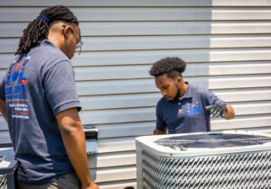 HVAC technicians from Cool Guys Heating & Air LLC inspecting an outdoor AC unit in North Little Rock, AR.