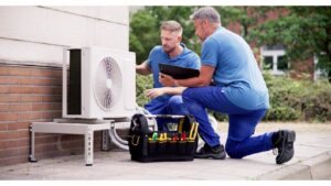 Two HVAC technicians inspecting an outdoor mini-split air conditioning unit for Shook Heating And Cooling in Livonia, MI.