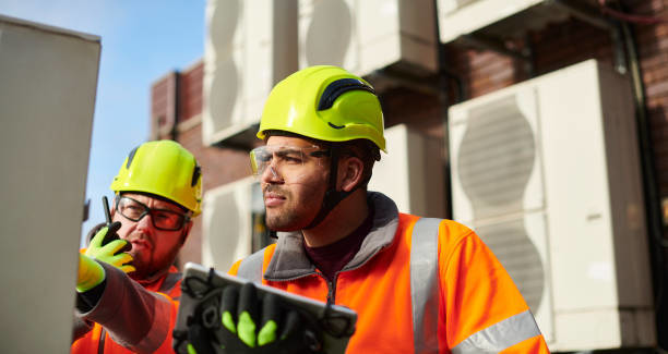HVAC technicians inspecting outdoor units for Controlled Climate Solutions in Decatur, AL.