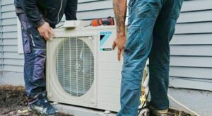 Two HVAC technicians installing an outdoor Daikin air conditioning unit for DND Mechanical in Columbus, OH.