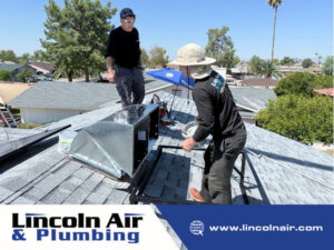 Two Lincoln Air & Plumbing technicians installing or repairing ductwork on a residential roof in Phoenix, AZ