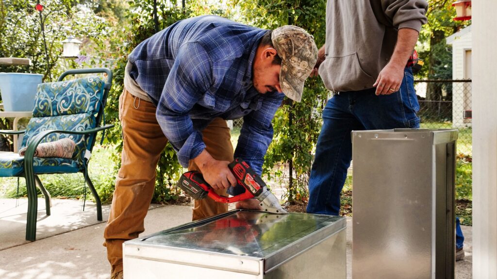 Mucciante Heating & Cooling technicians installing custom metal ductwork for an HVAC system in Pekin, IL.