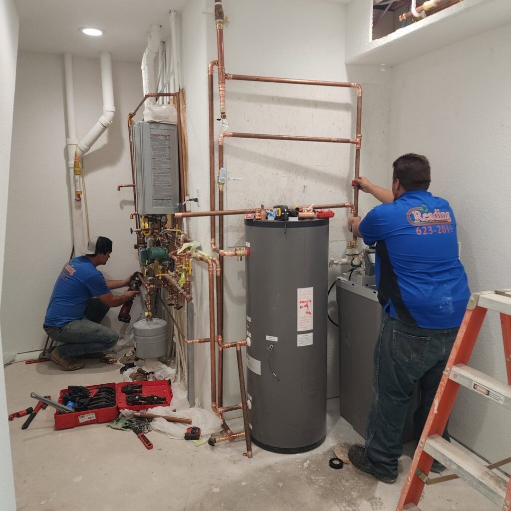 HVAC technicians installing a heating system for Reading Plumbing, Heating & Air Conditioning in Roswell, NM