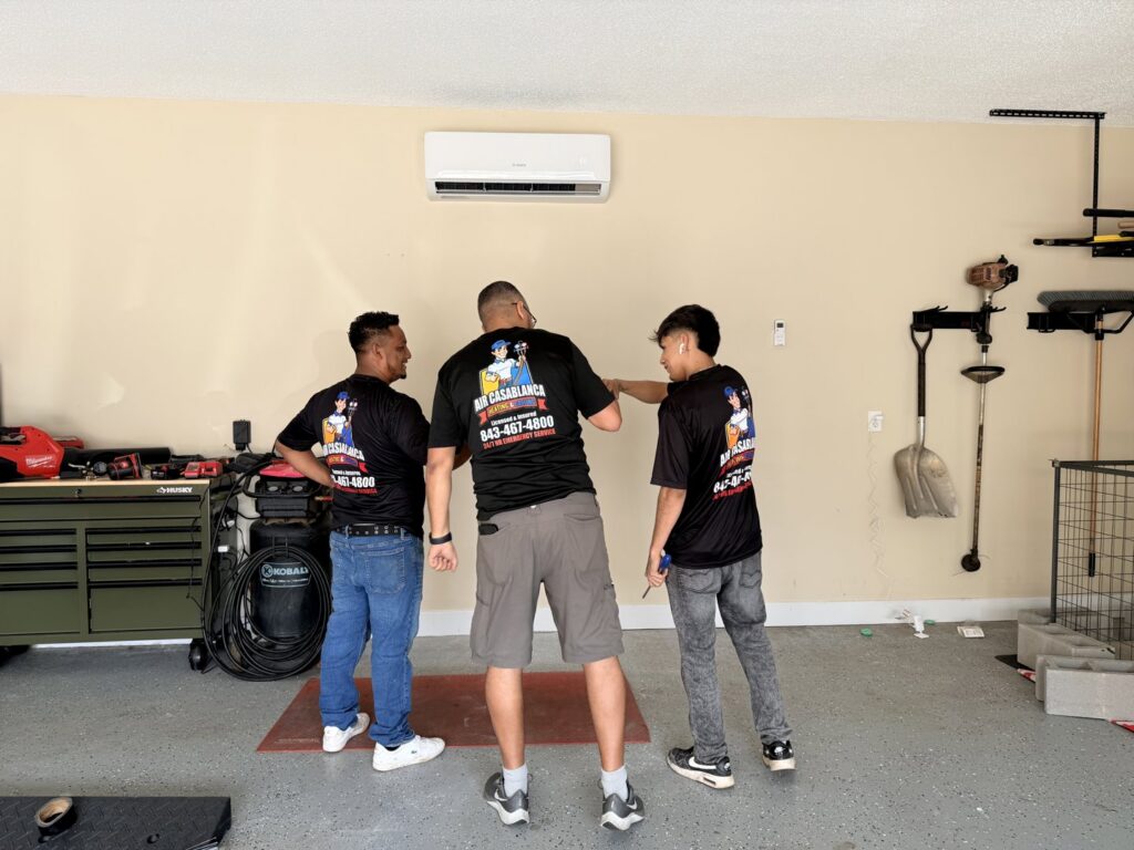 Three HVAC technicians from Air Casablanca Heating & Cooling installing a mini-split indoor unit in Myrtle Beach, SC.